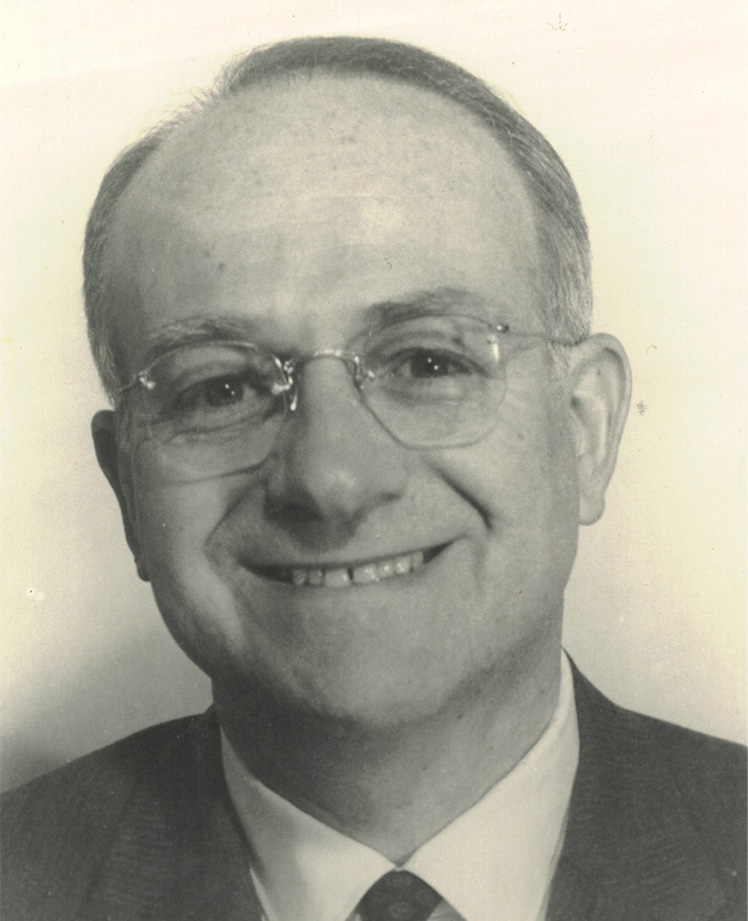 A smiling Dr. Morris Collen wearing a suit and tie.